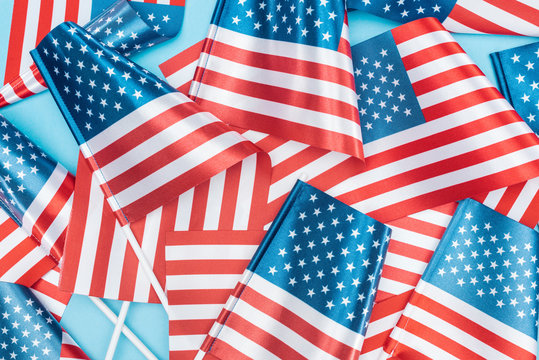 top view of national american flags on sticks scattered on blue background