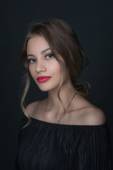 Fototapeta premium Beautiful ,young blonde with bright red lips and expressive eyes in a black jumpsuit. Beauty portrait of a girl. Emotional and bright appearance. Fashion portrait of a woman.