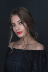 Fototapeta premium Beautiful ,young blonde with bright red lips and expressive eyes in a black jumpsuit. Beauty portrait of a girl. Emotional and bright appearance. Fashion portrait of a woman.