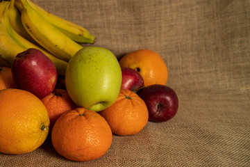 red and green apples orange banana and tangerine of a sackcloth