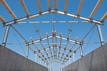 The metal frame of the building on a reinforced concrete base. The use of materials from metal and concrete in modern construction.