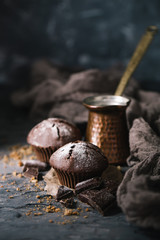 Muffin with coffee on dark textured background.
