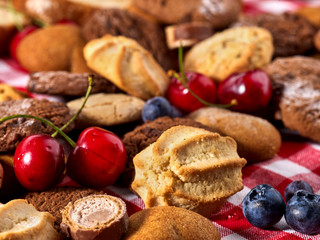 Cookies and sand biscuit on tier cake stand with blueberry chocolate on kitchen on picnic table in rustic natural style. Homemade, delicious recipes.