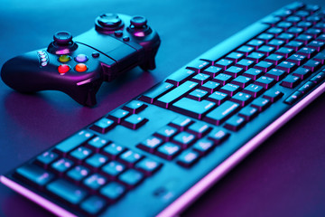 Keyboard and joystick on violet table background.