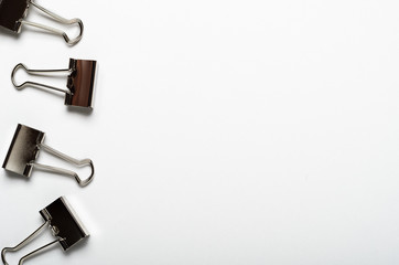 Silvery stationery clips on a gray background. Office stationery. Copy space, top view, flat lay.