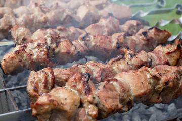 Shashlik pork on skewers close up. Meat roasted on an open fire on the grill. Selective focus.