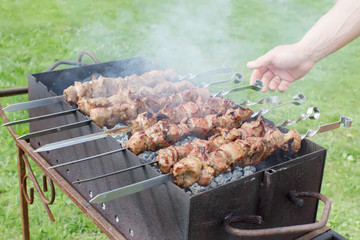 Shashlik pork on skewers.  Meat roasted on an open fire on the grill. Nature. Selective focus. 