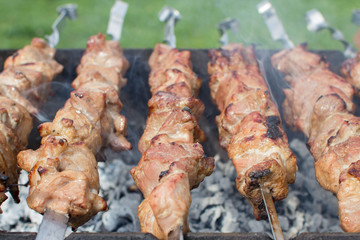 Shashlik pork on skewers close up. Meat roasted on an open fire on the grill. Selective focus.