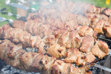 Shashlik pork on skewers close up. Meat roasted on an open fire on the grill. Selective focus.