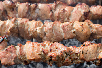 Shashlik pork on skewers close up. Meat roasted on an open fire on the grill. Selective focus.