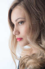 Naklejka premium Beautiful ,young blonde with bright red lips and expressive eyes in a black jumpsuit. Beauty portrait of a girl. Emotional and bright appearance. Fashion portrait of a woman.