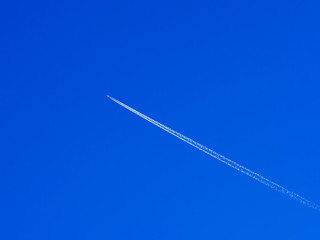 airplane contrail against clear blue sky with copy space