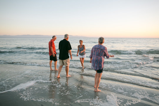 Four adult friends together on beach