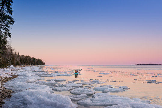 Man kayaks peacefully in Ontario winter landscape