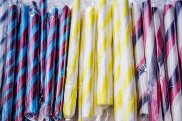 Close-up of colorful sugar sticks, sweet temptation in bright, fresh colors, sugary aromas, on a street market.