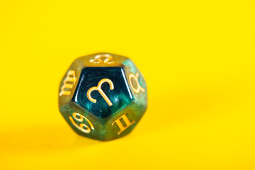 Astrology Dice with zodiac symbol of Aries Mar 21 - Apr 19 on bright yellow background