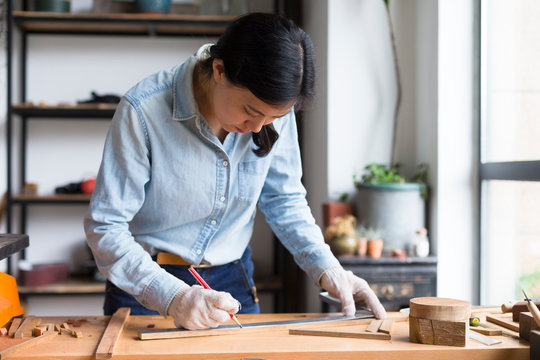 Female carpenter working In Carpentry Workshop