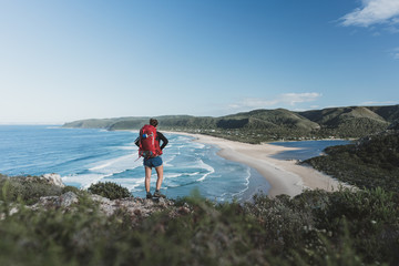 Hiker overlooking a scenic coastline