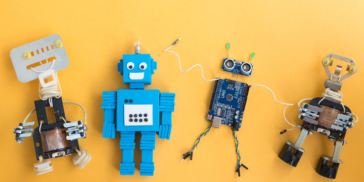Back to school concept. A metal robot and an electronic board that can be programmed. Robotics and electronics. DIY robotics. STEM and STEAM education for kids. Free space for text.
