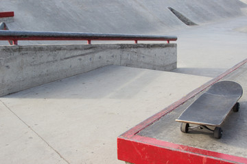 Skateboard lies in the background in a deserted skatepark