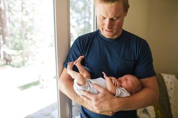 Man holding new baby inside.
