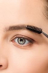 cropped view of woman shaping eyebrow with eyebrow brush