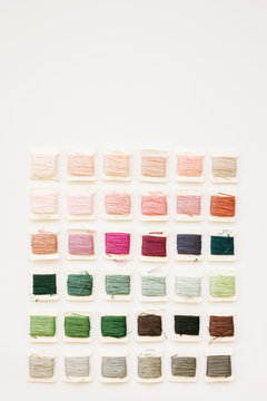 colorful embroidery thread arranged on a white background