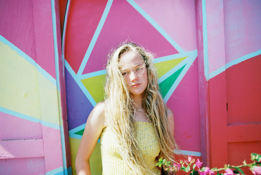 blonde teenage girl with long wavy hair with bright colors in summer