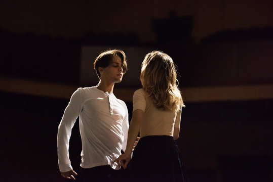 Artistic dancers on stage in light