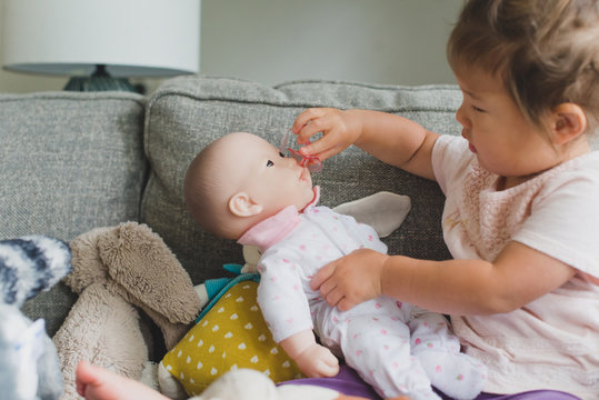 Baby playing with baby doll