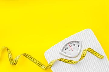 Slim concept with scale and measuring tape on yellow background top view mockup