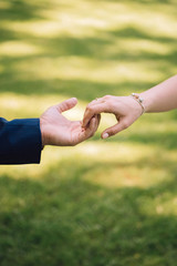 young couple puts on wedding rings. boy and girl hold hands. married couple.