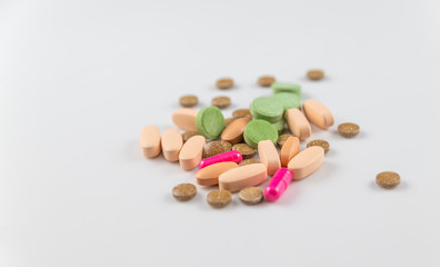 medical pills of different colors and shapes isolated on a white background