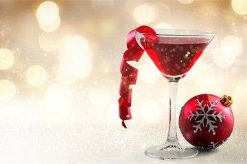 Glass of red wine and Christmas decoration on background