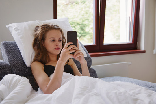 Woman lying and using smartphone