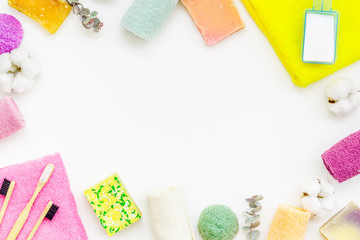 Wash and care products and cotton towels frame on white background top view space for text