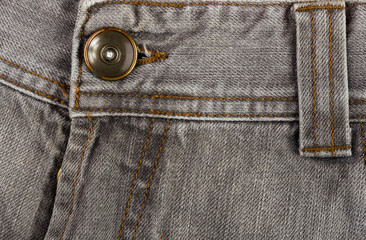 clothing items stonewashed cotton fabric texture with seams, clasps, buttons and rivets, macro