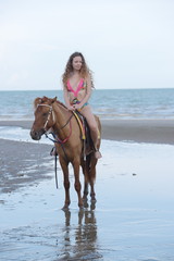 Portraits of beautiful women riding horses happily at the beach by the sea