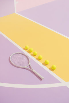 Tennis balls and racket on colorful course