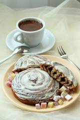 cinnamon puff and butter cream on a plate decorated with Turkish delight and a cup of coffee