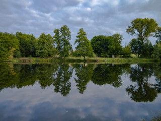 Fototapeta na wymiar Cloudy summer day beautiful nature reflection on the lake surface