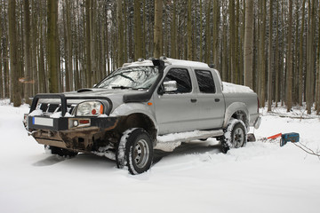 Snow covered car in forest