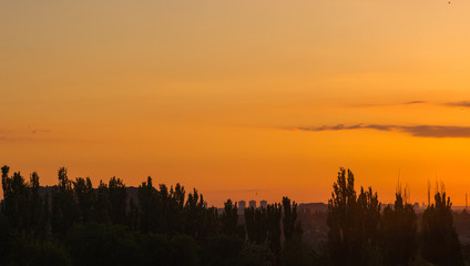 Landscape with dramatic light - beautiful golden sunset with saturated sky and clouds.