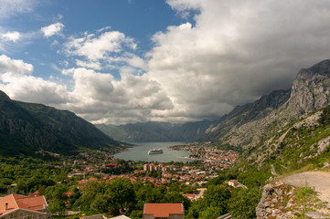 Fototapeta premium Bay of Kotor from the heights. View from Mount Lovcen to the bay. View down from the observation platform on the mountain Lovcen. Mountains and bay in Montenegro. The liner near the old town of Kotor.
