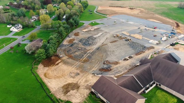 Aerial pull back from a ​construction site and parking lot to reveal Lancaster Evangelical Free Church, Lititz Pennsylvania