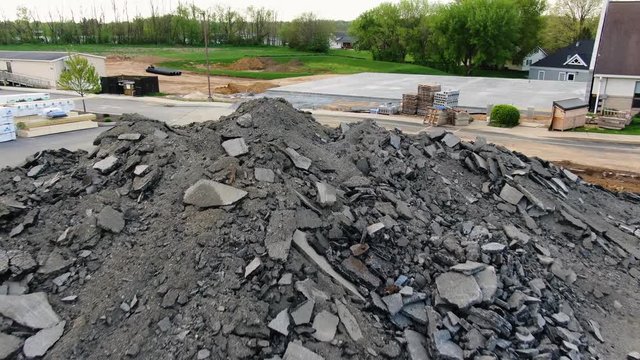 Aerial slow pass close up over a large pile of chewed up asphalt chunks, Lancaster Evangelical Free Church, Lititz Pennsylvania