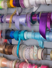 multicolored threads and ribbons. Background for the store selling reels with ribbons. materials for sewing and creativity. Fashionable craft of women.