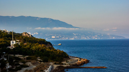 Russia. Crimea. Evening surroundings of the sanatorium Kurpaty. Yalta is visible behind the cape