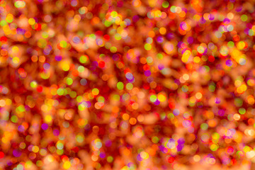Background of blur colorful texture bokeh for Festival and New year. Game of color. Abstract Christmas orange and yellow backdrop.