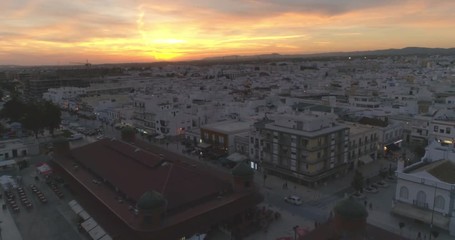 Aerial sunset cityscape of Olhao downtown, Algarve fishing village view of ancient neighbourhoods traditional cubist architecture and landmark market. Portugal.